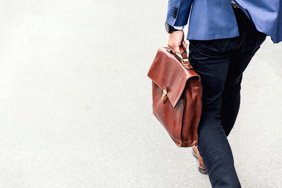 Business man holding a briefcase walking by