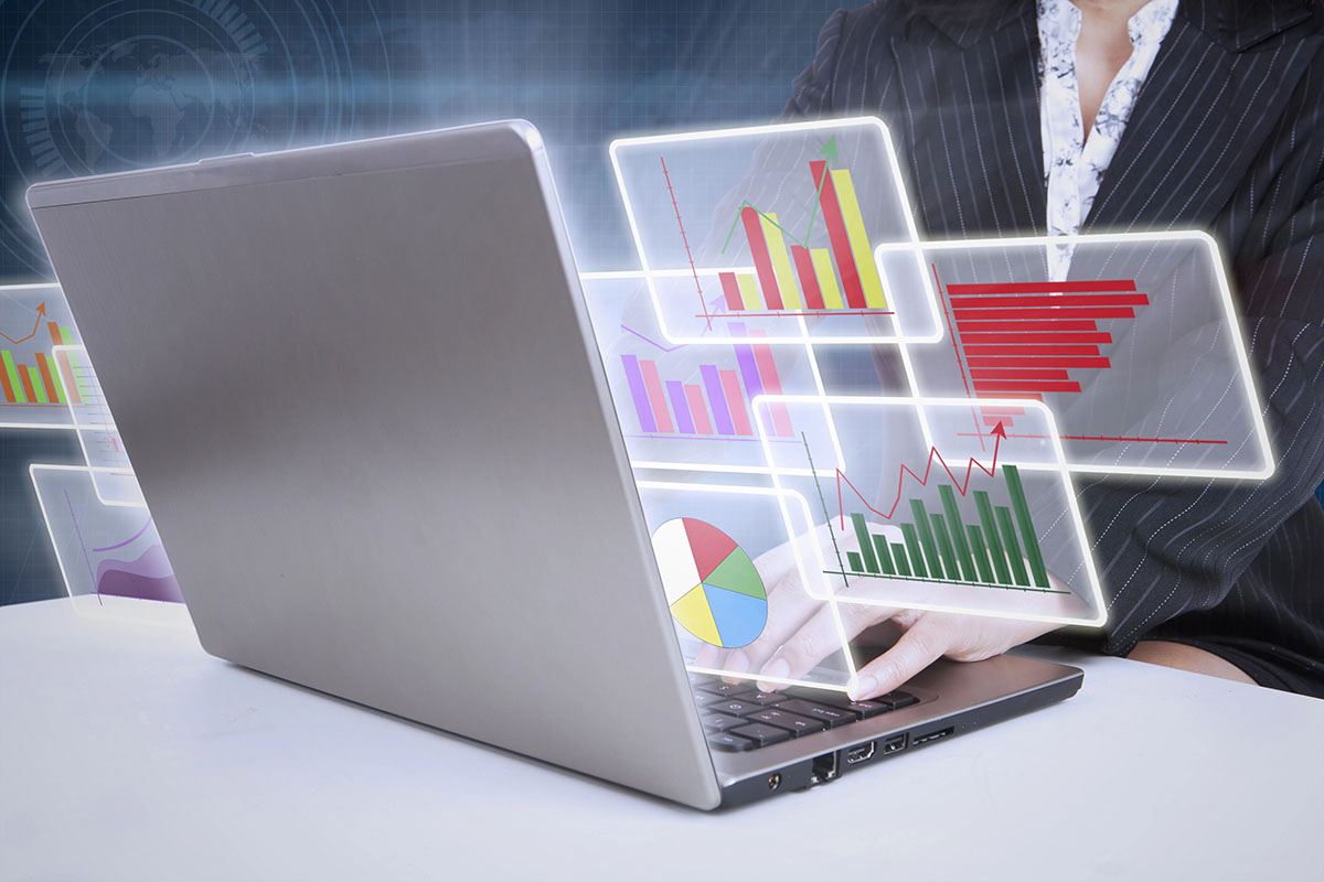 A person in a business suit is typing on a laptop, surrounded by floating digital graphs, charts, and visual data elements illustrating analytics and statistics.