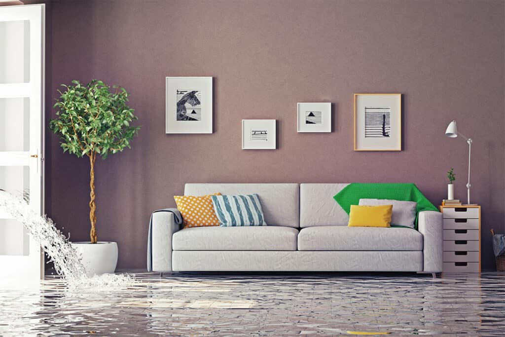 A modern living room with water rushing through an open doorway, completely covering the floor in standing floodwater.