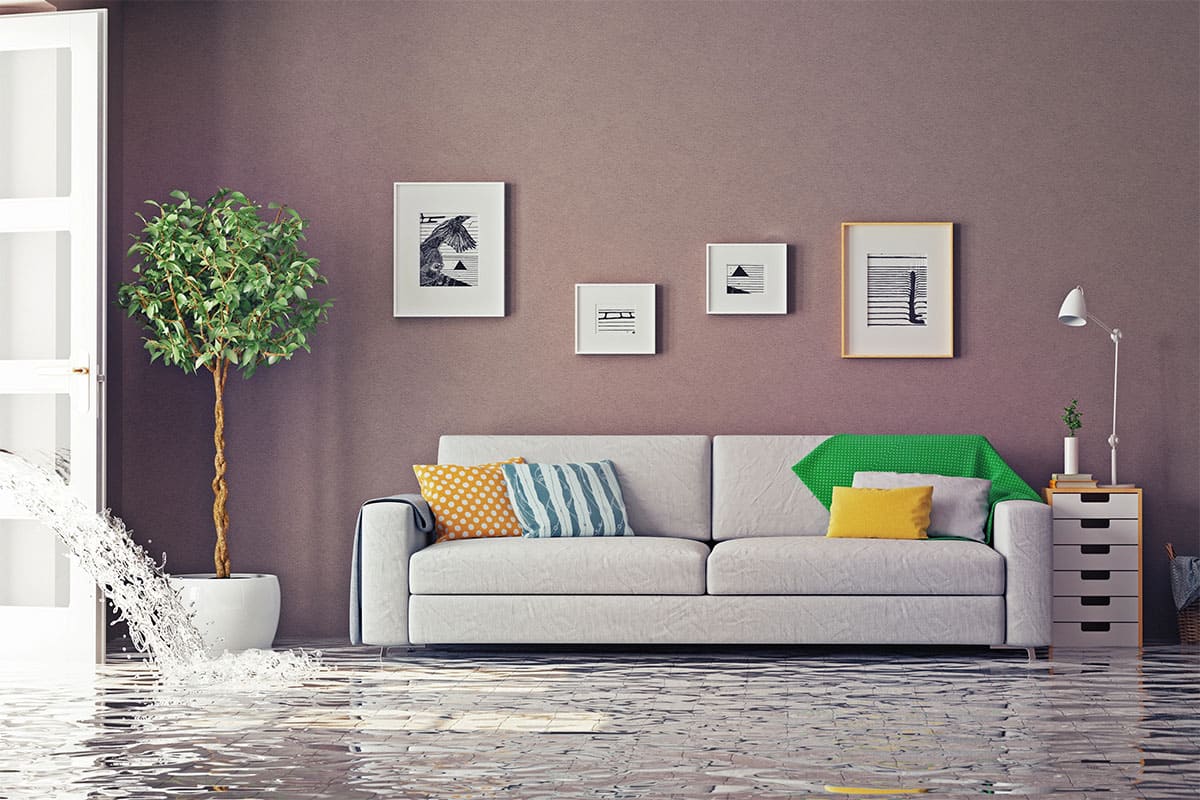 A modern living room with water rushing through an open doorway, completely covering the floor in standing floodwater.